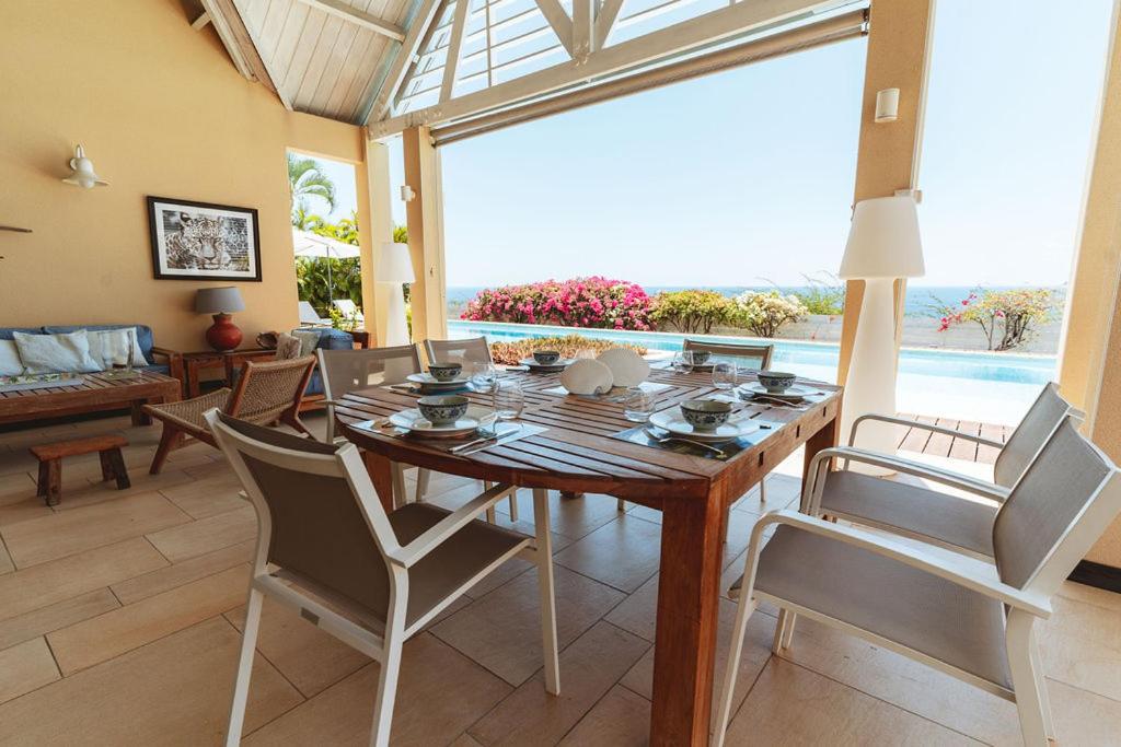 Espace repas de la terrasse couverte avec vue sur l’océan