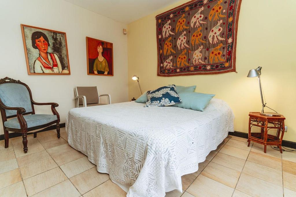 Chambre double avec tapisserie murale, tableaux et bureau