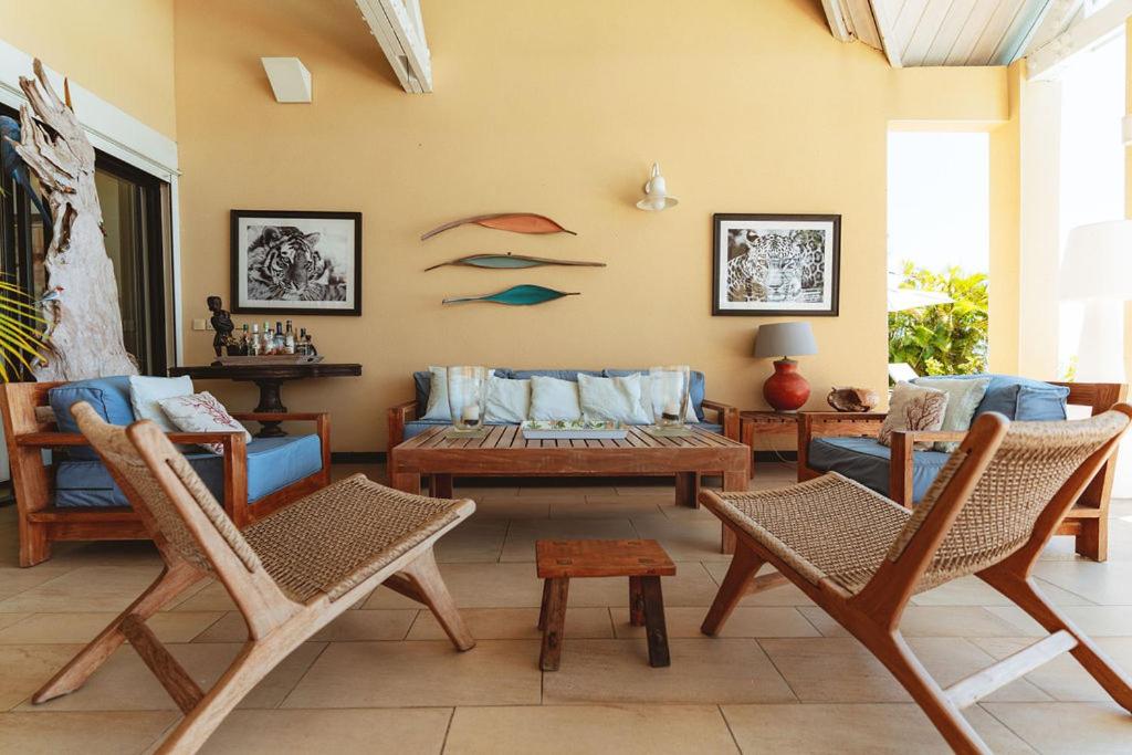 Salon de la terrasse avec fauteuils en bois et décoration de poissons