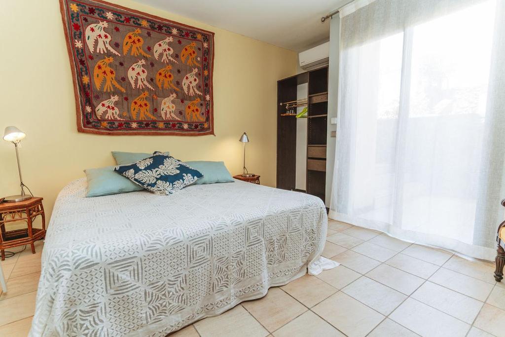 Chambre double avec tapisserie murale et accès direct au jardin