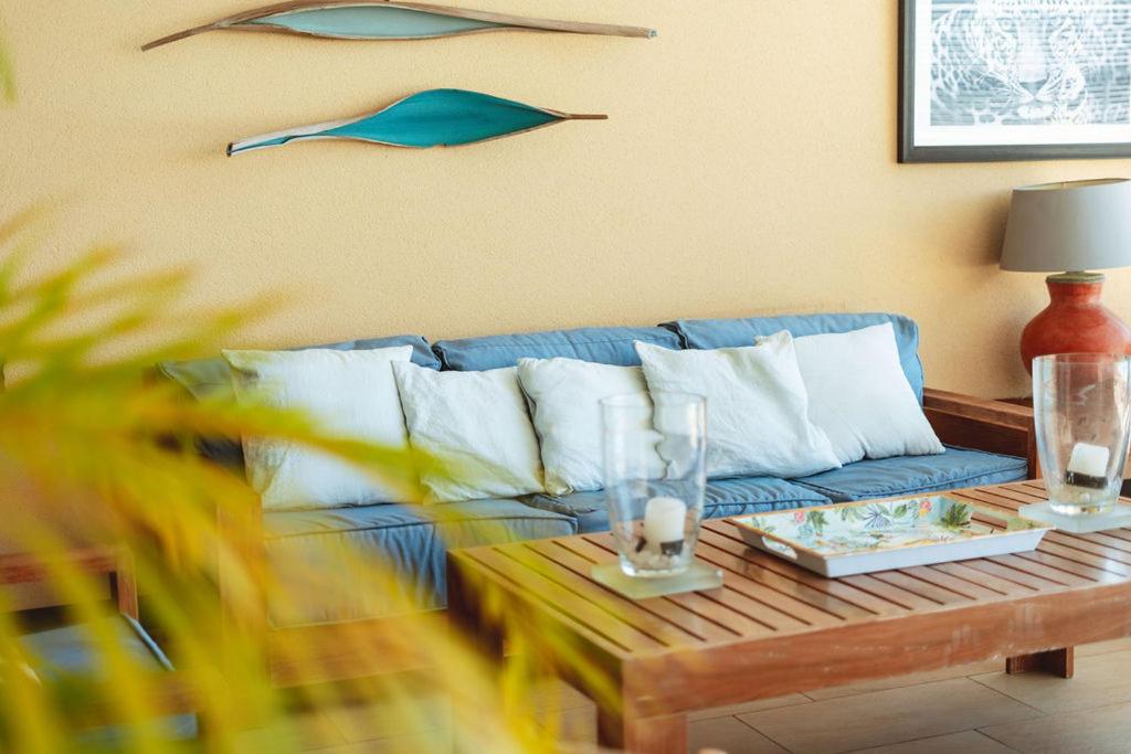 Salon extérieur de la véranda avec canapé bleu et table basse en bois