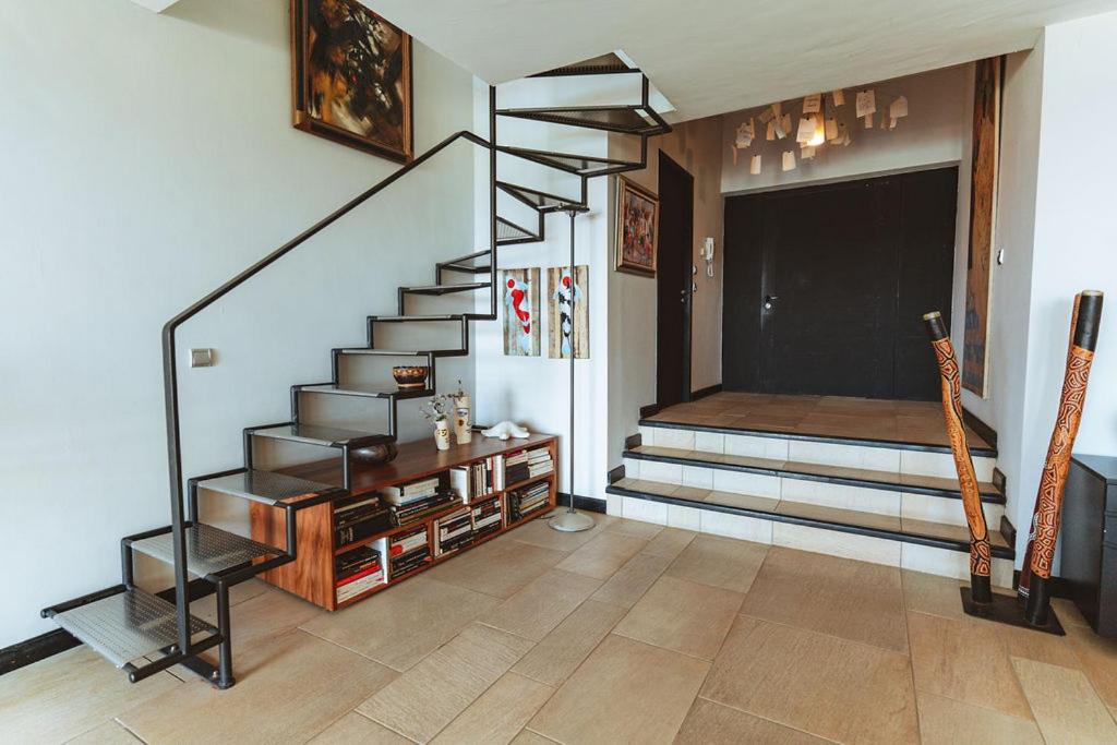 Entrée de Villa Lakaz avec escalier métallique et bibliothèque