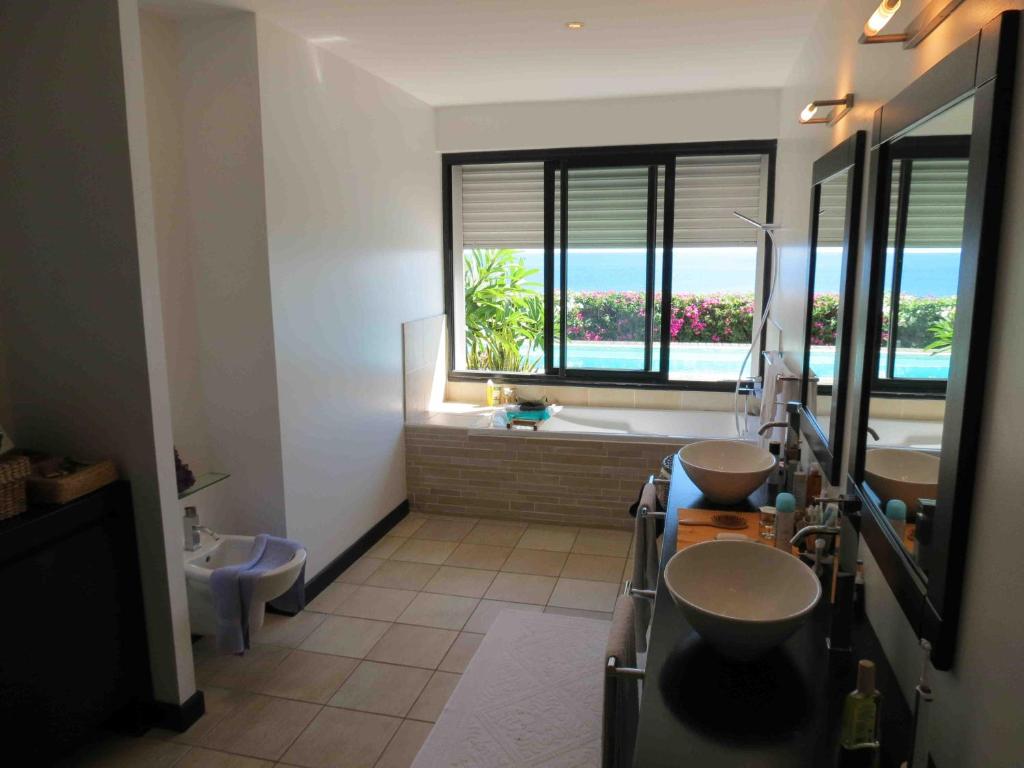 Salle de bain avec double vasque, baignoire et vue sur la mer