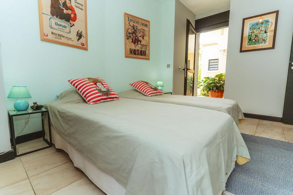 Chambre à lits jumeaux avec affiches de cinéma et accès au jardin